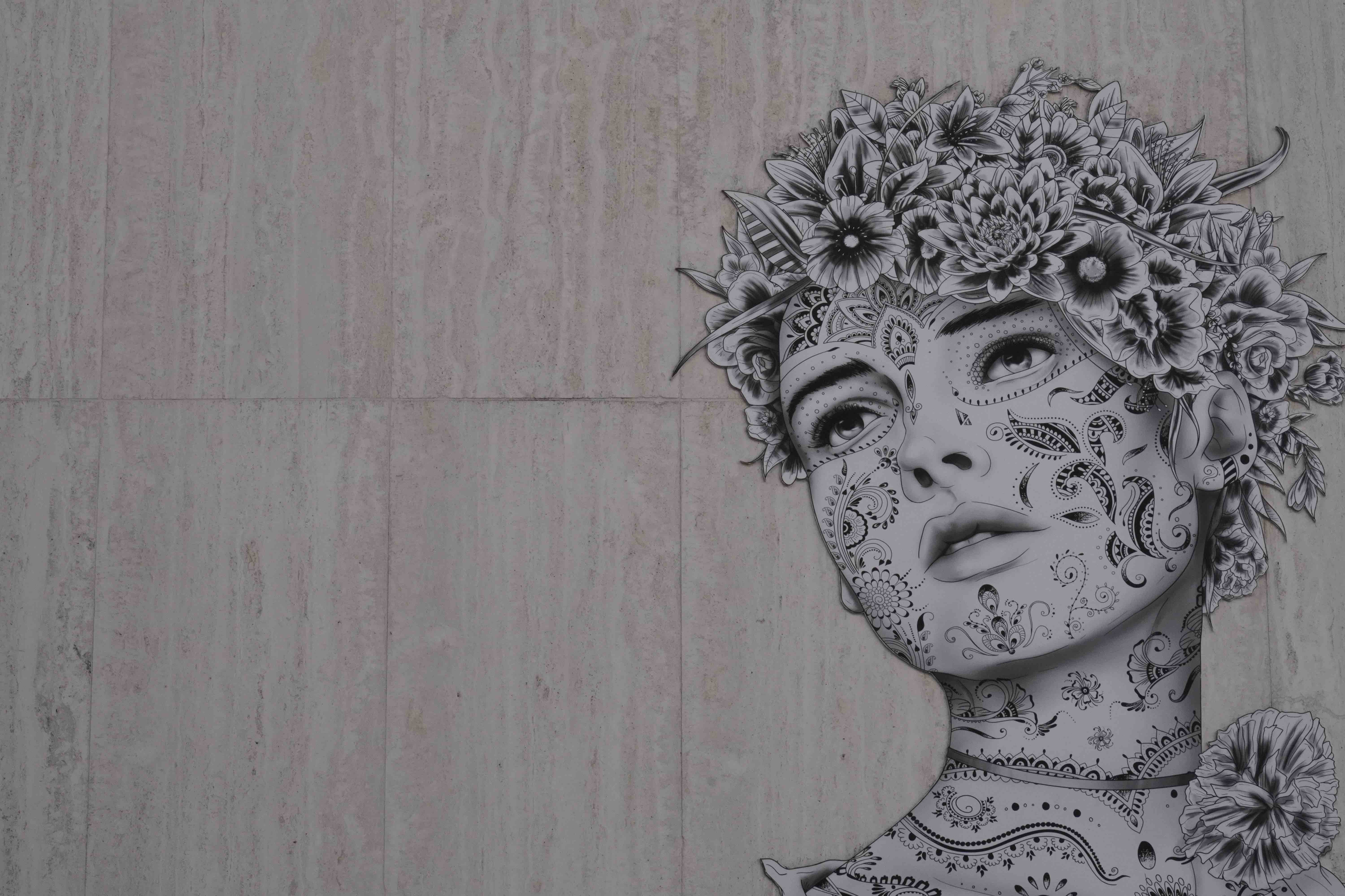 Detailed graffiti art of a woman's head with floral decor.
